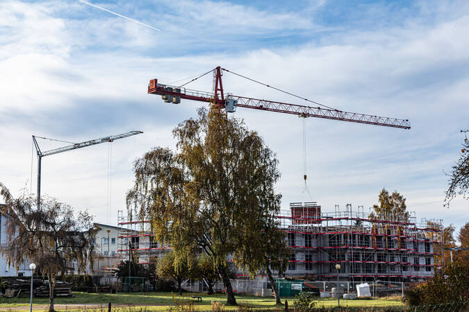 Zwei gelbe Baukräne bei einer Baustelle für ein Haus. Zwei gelbe Baukräne bei einer Baustelle für ein Haus.